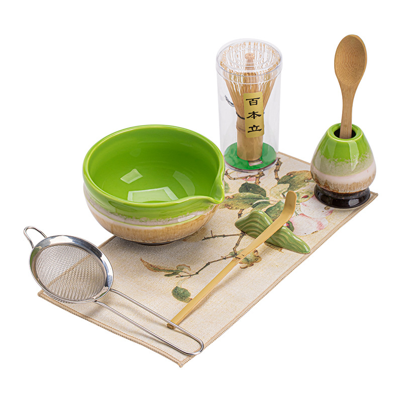 Bộ trà đạo matcha kiểu Nhật bốn món với bát trà chải bằng lò nung, dụng cụ pha trà và dụng cụ khuấy trà.