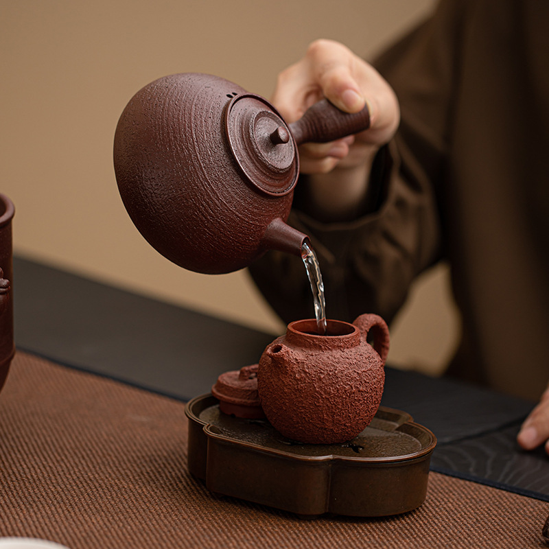 Bộ đồ pha trà trong lò cồn màu nâu đỏ và nuyuan bằng bùn đá cũ, ấm trà bên đế làm nóng bằng gốm, bộ trà Kung Fu