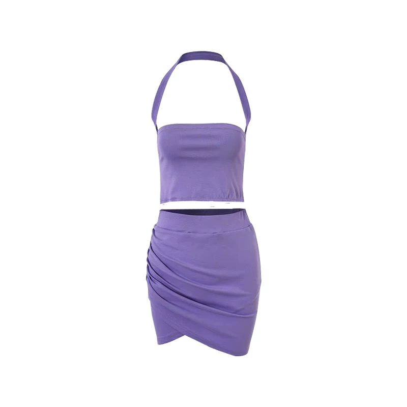 Bộ trang phục gồm áo crop top ôm sát cổ halter và chân váy xếp ly ôm sát eo cao dành cho nữ.