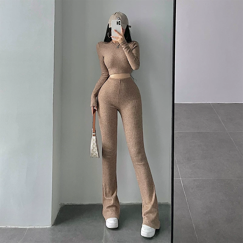 Bộ đồ nữ gồm áo crop top ôm sát tay dài gợi cảm và quần ống loe cạp cao phong cách casual.