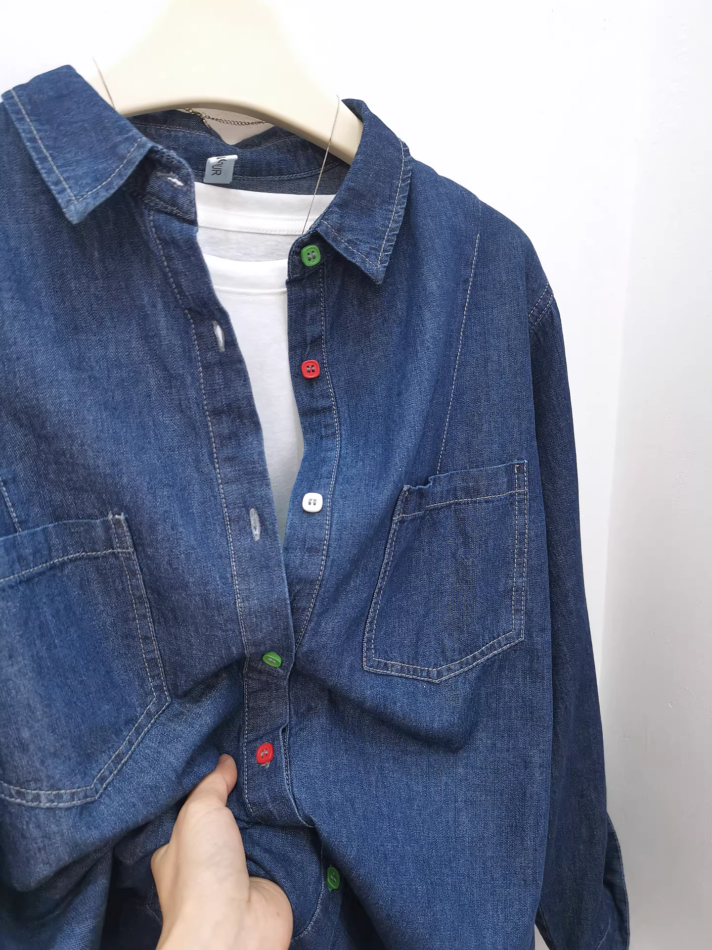 Áo sơ mi denim nữ màu xanh đậm, chất liệu cotton nguyên chất, dáng dài tay, hai túi, kiểu dáng vintage ôm vừa, nhiều lớp, màu sắc tươi sáng.