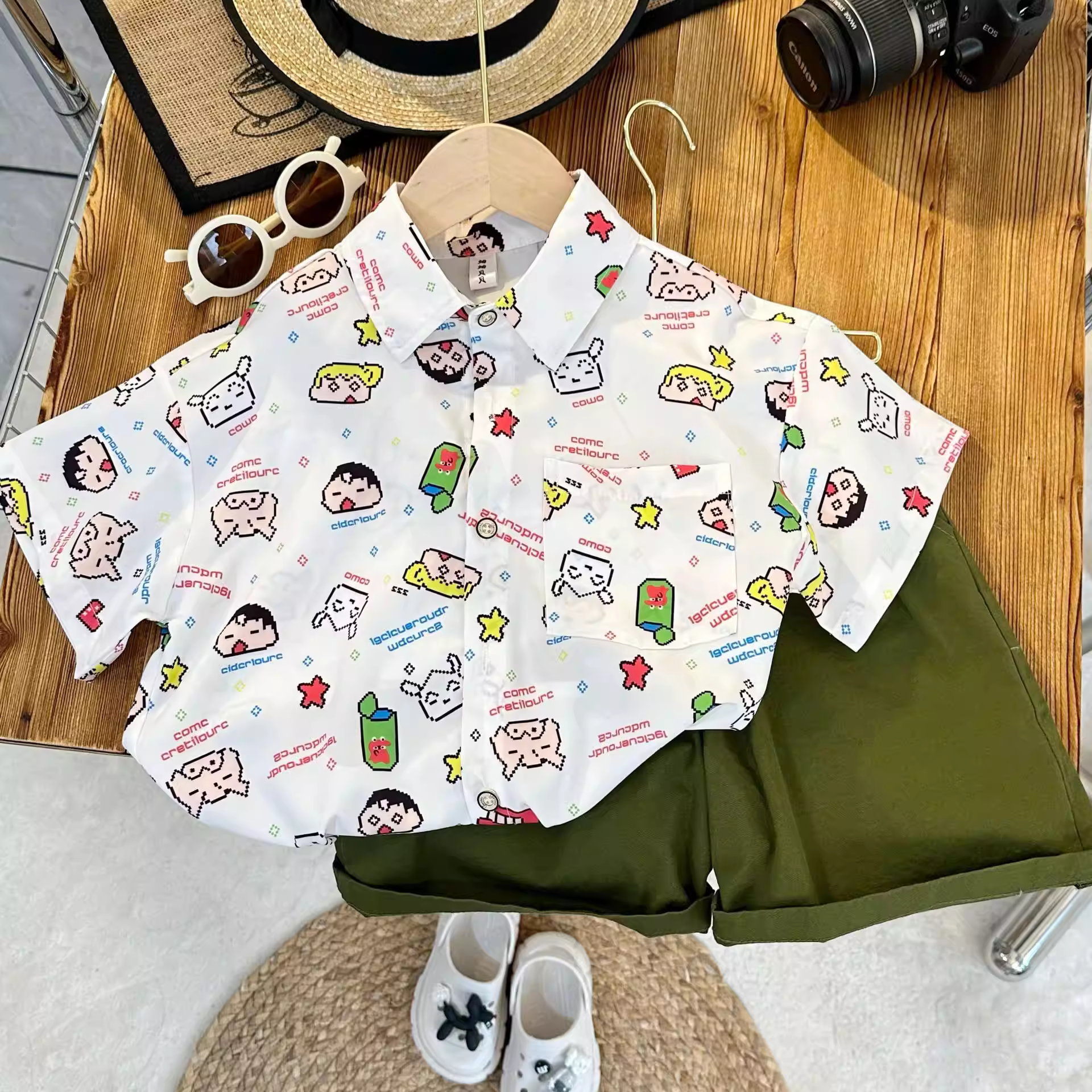 Áo sơ mi trẻ em tươi mát và giản dị trong mùa hè năm 2025. Áo sơ mi ngắn tay có cổ in họa tiết thời trang của Crayon Shin-chan dành cho bé trai là loại mỏng.