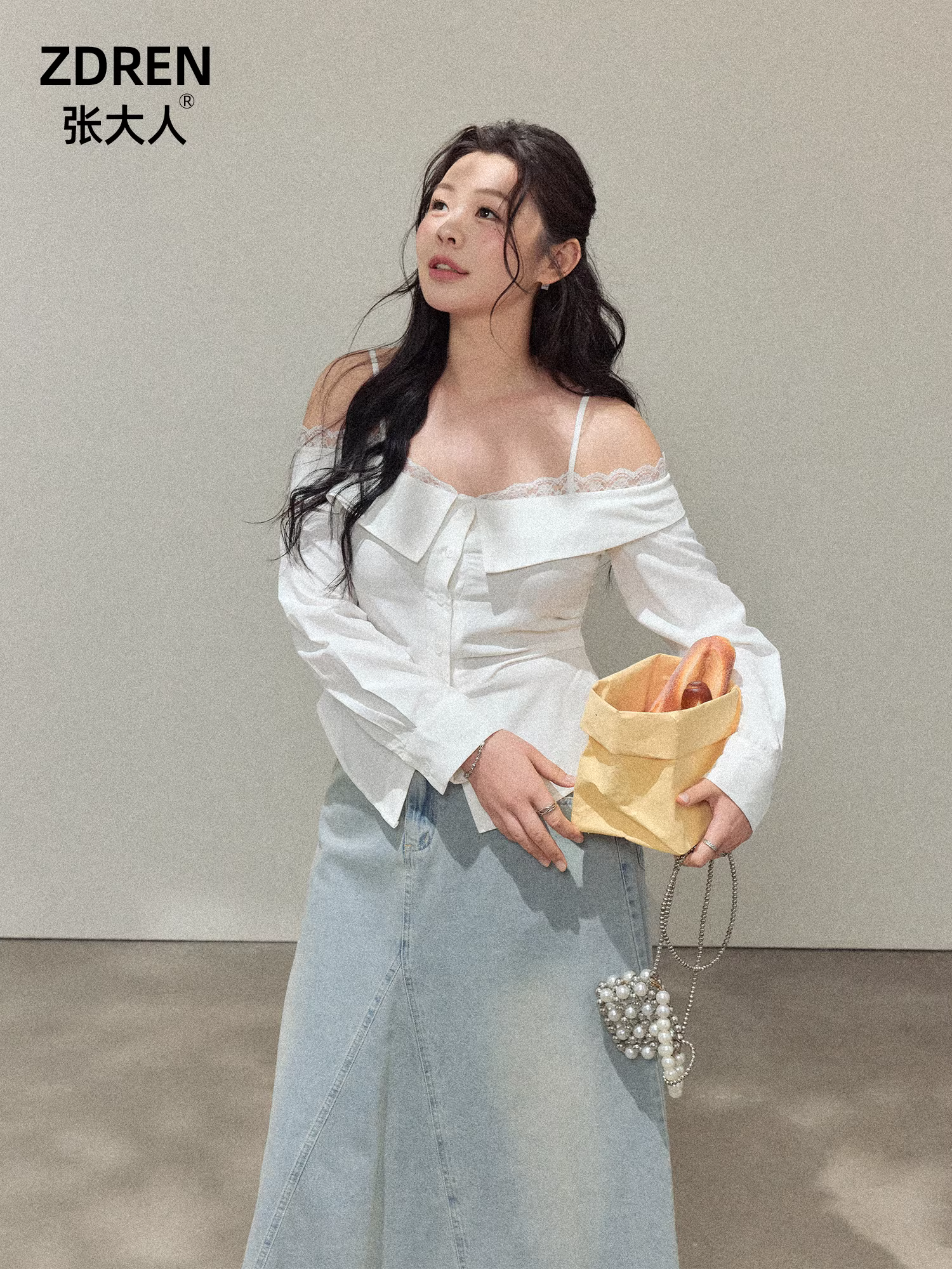 Quần áo nữ cỡ lớn dành cho người lớn, áo trắng trễ vai phối cùng chân váy denim nhẹ, trang phục tôn dáng.