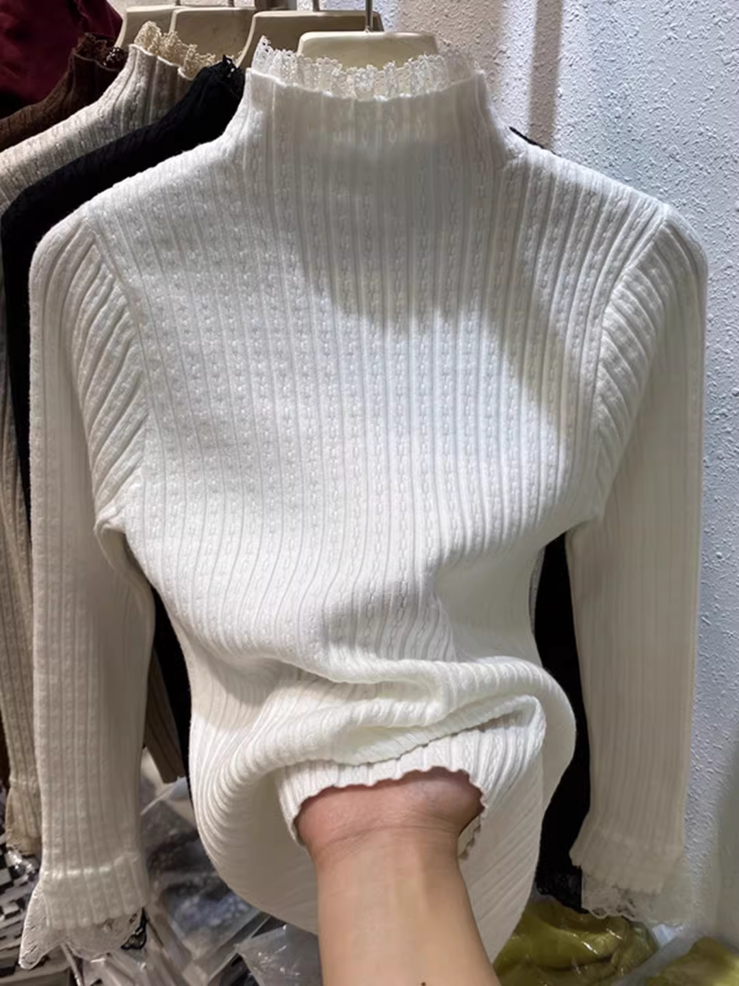 Hàng thanh lý quần áo nữ có mác cắt, áo len dệt kim phối ren cổ nửa cao, lớp trong màu trơn, kiểu dáng độc đáo.