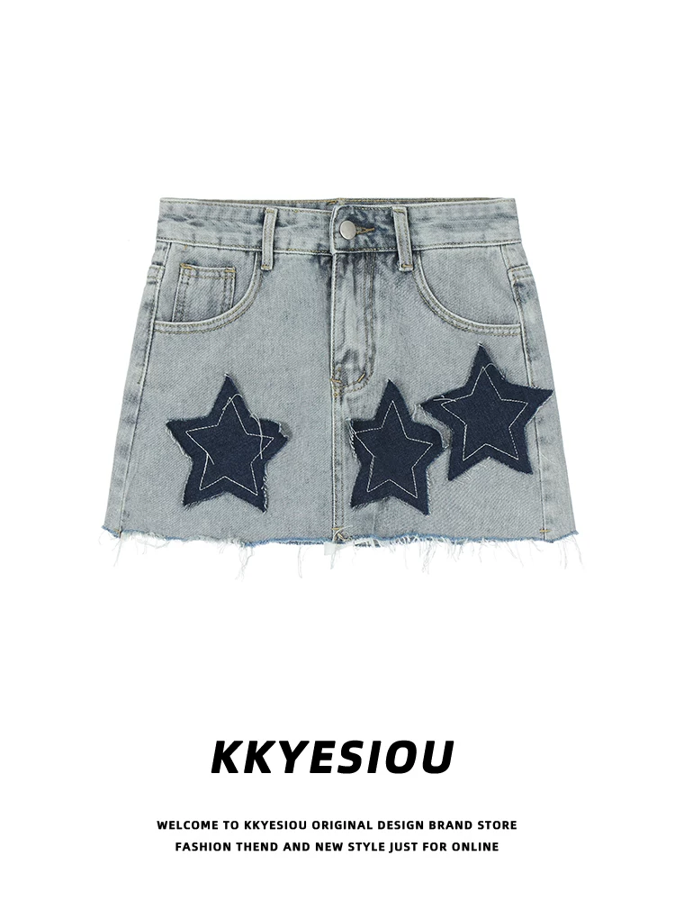 Chân váy denim ngắn thêu họa tiết lấy cảm hứng từ phong cách đường phố Mỹ của KKyesiou dành cho nữ, với viền thô, cạp cao và kiểu ôm sát.