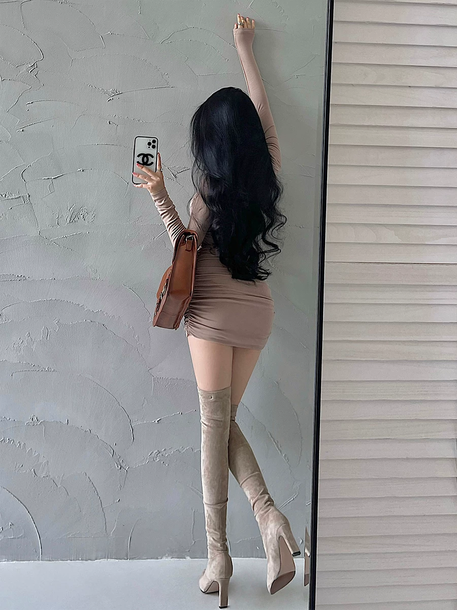 YoungGirlDay phong cách thuần khiết gợi cảm, váy ôm sát cổ cao, tay dài, có chi tiết xếp nếp, kèm chân váy ngắn ôm hông.