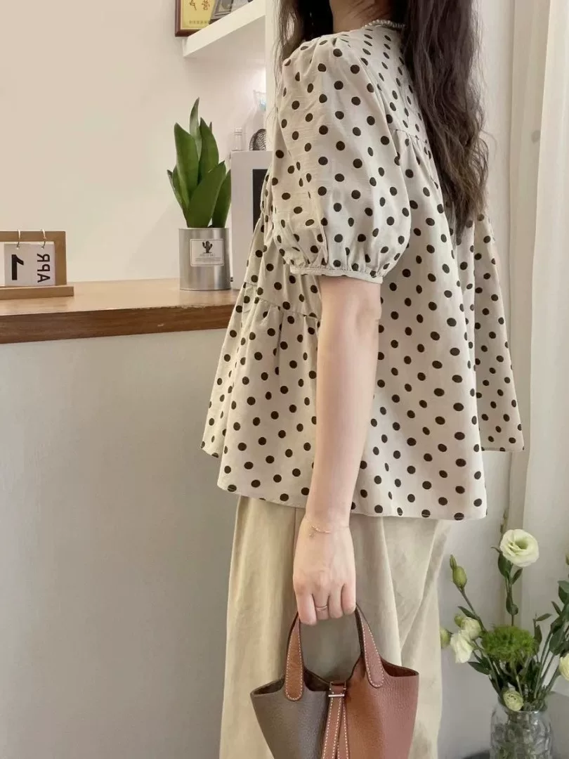 Áo sơ mi babydoll chấm bi kiểu mới hè 2025, dáng rộng, tay bồng xếp ly, giúp thon gọn dành cho nữ cỡ lớn.