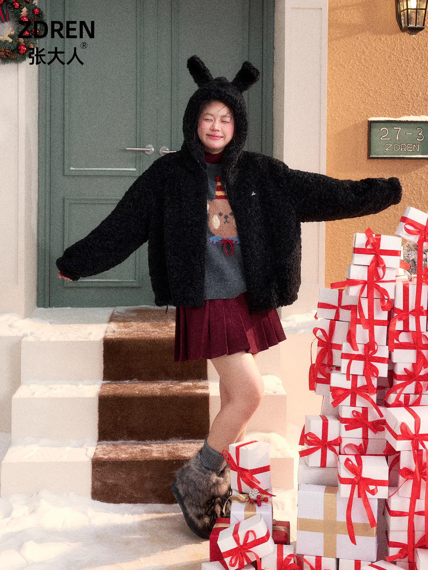 Bộ quần áo mùa đông cho phụ nữ cỡ lớn, gồm áo khoác len cừu đen có mũ và chân váy xếp ly, giúp thon gọn dáng người cho các cô gái mũm mĩm.