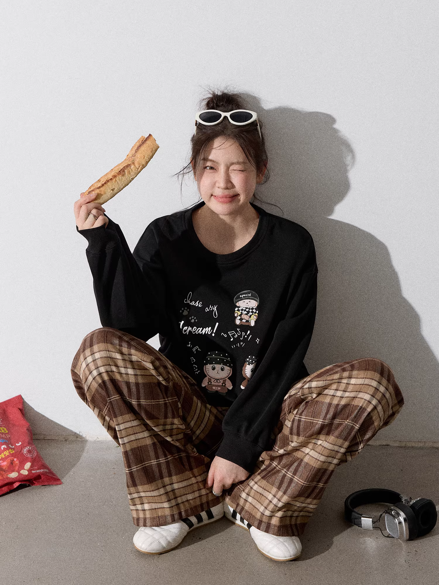 Quần áo nữ cỡ lớn dành cho người lớn, bộ áo nỉ đen cổ tròn kiểu dáng thu mới giúp thon gọn và quần kẻ sọc nâu.