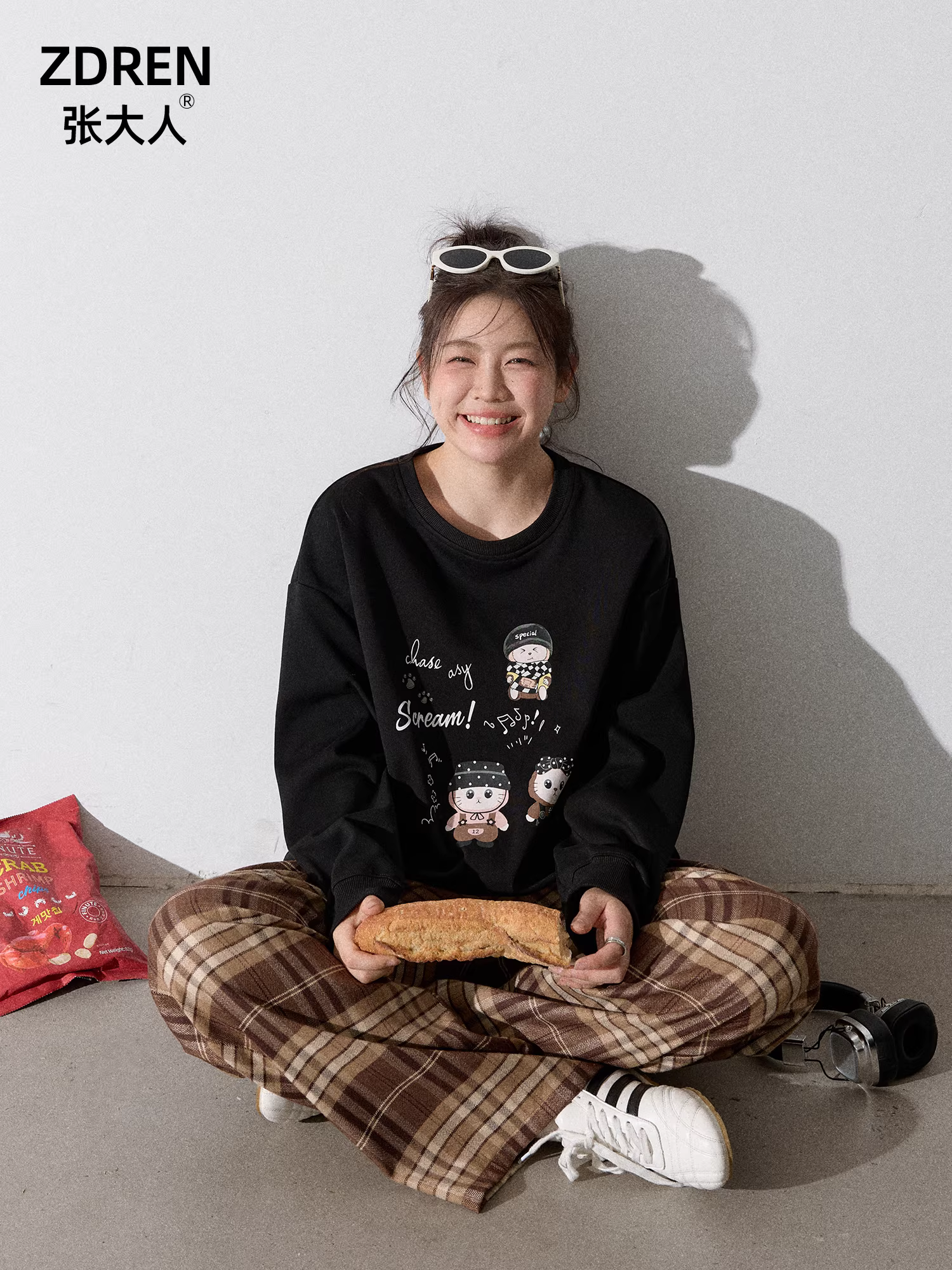 Quần áo nữ cỡ lớn dành cho người lớn, bộ áo nỉ đen cổ tròn kiểu dáng thu mới giúp thon gọn và quần kẻ sọc nâu.