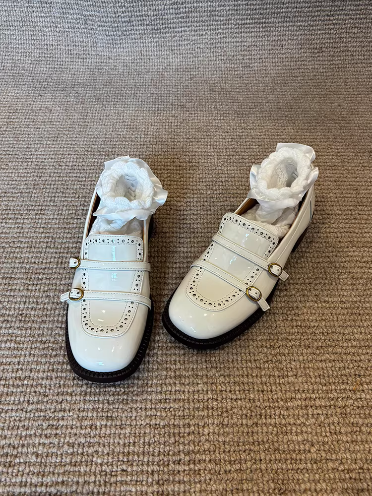 Giày lười da cừu kiểu Anh, chất liệu da bóng, mũi tròn, gót dày, có khóa thắt lưng.