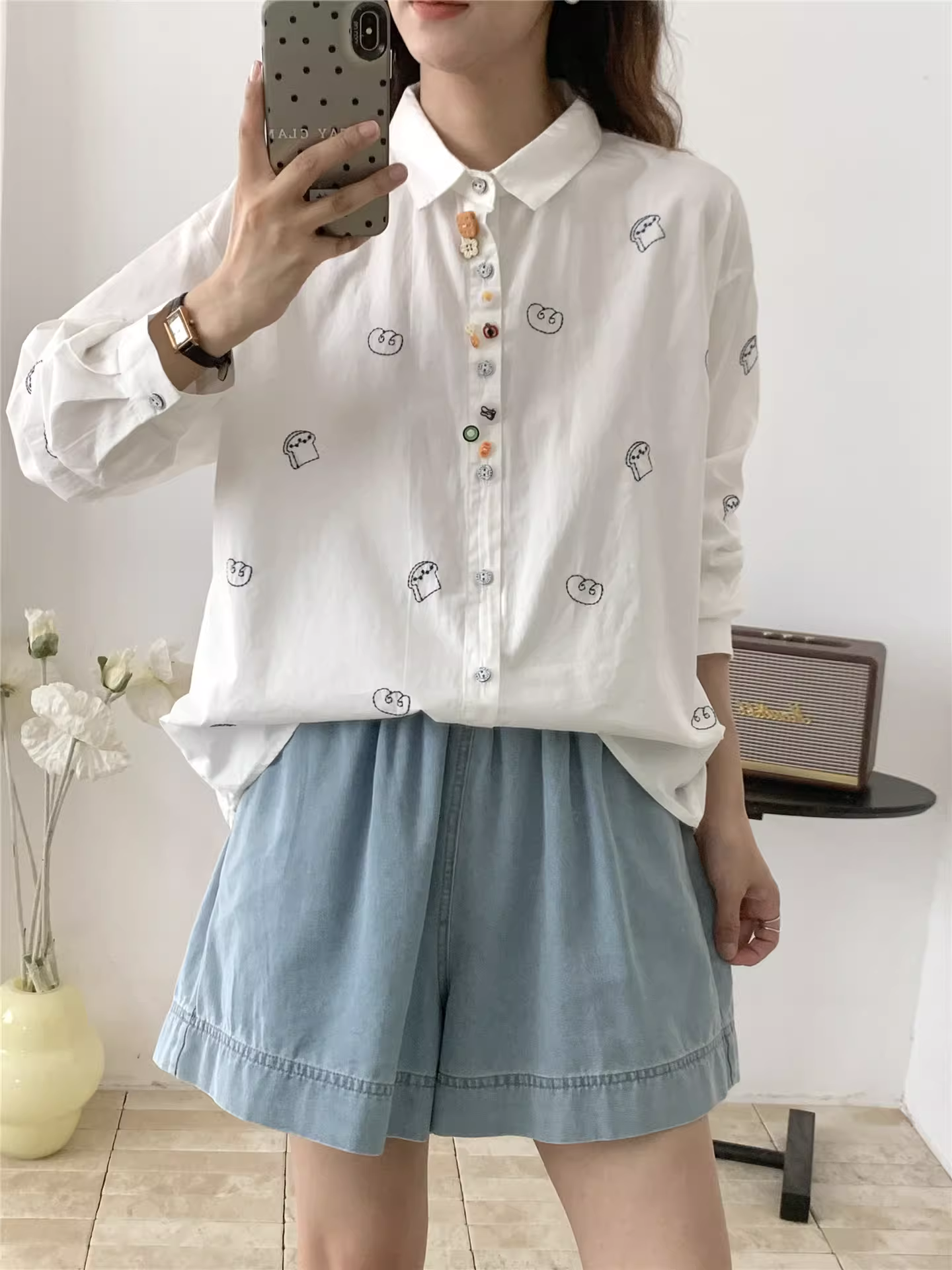 Áo sơ mi cotton thêu hình bánh mì mùa thu Dream Box 2025, cổ sơ mi, nhiều khuy, tay dài, dáng rộng, trẻ trung.