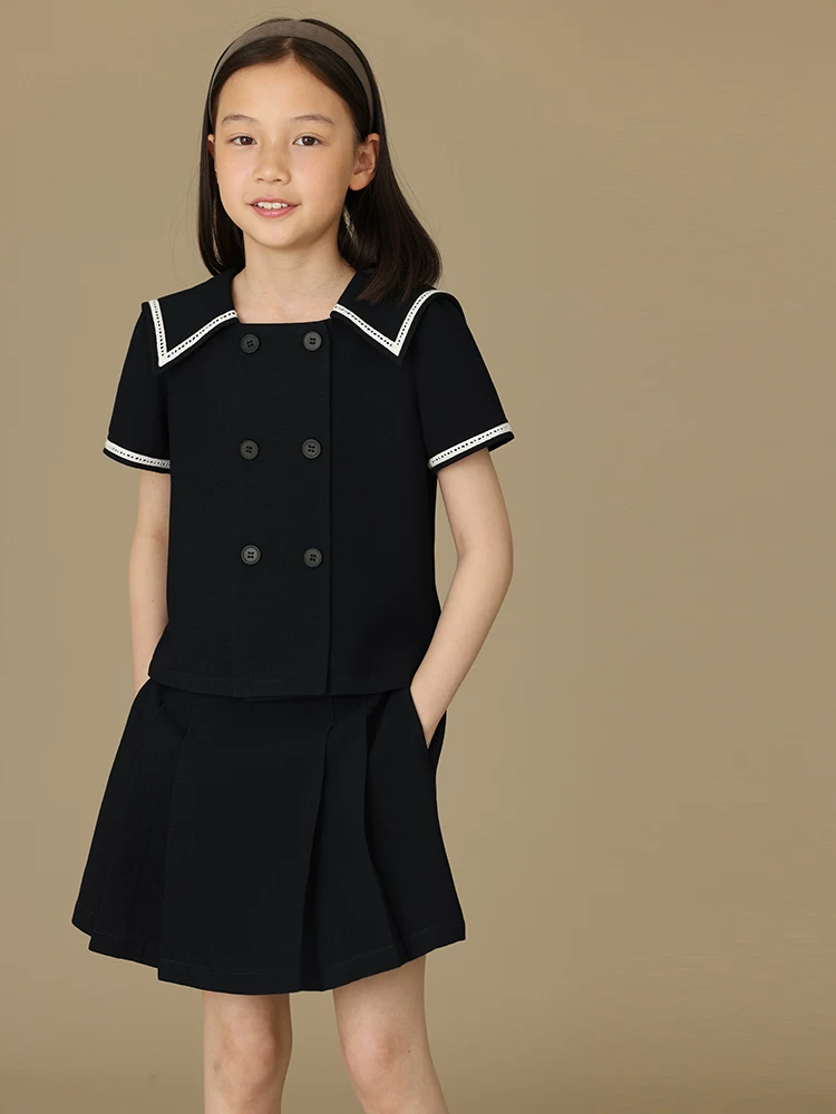 Bộ quần áo mùa hè cho bé gái gồm áo hai hàng khuy cổ vuông và chân váy xếp ly kiểu học sinh.