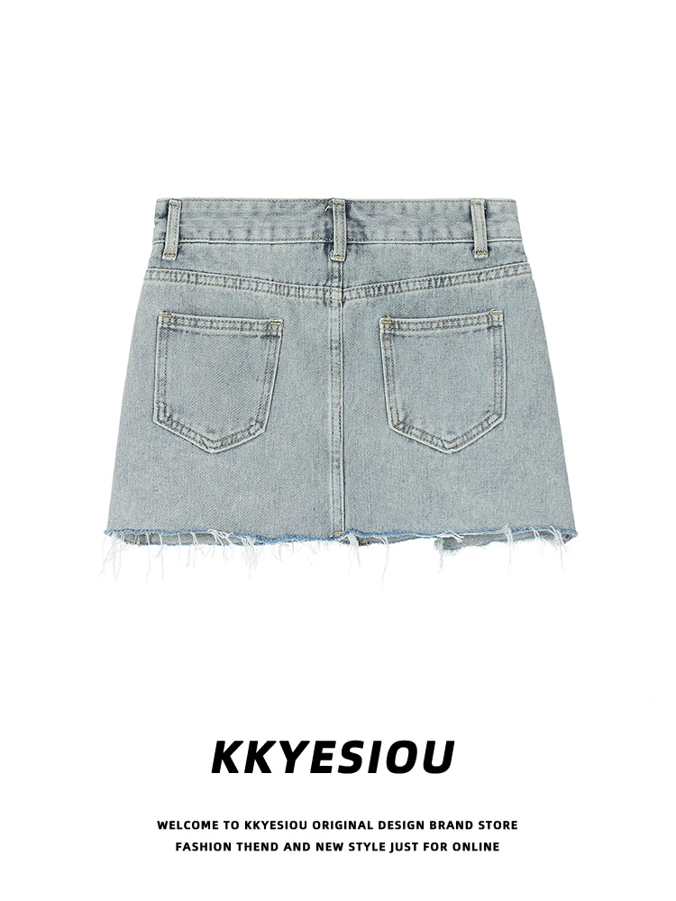 Chân váy denim ngắn thêu họa tiết lấy cảm hứng từ phong cách đường phố Mỹ của KKyesiou dành cho nữ, với viền thô, cạp cao và kiểu ôm sát.