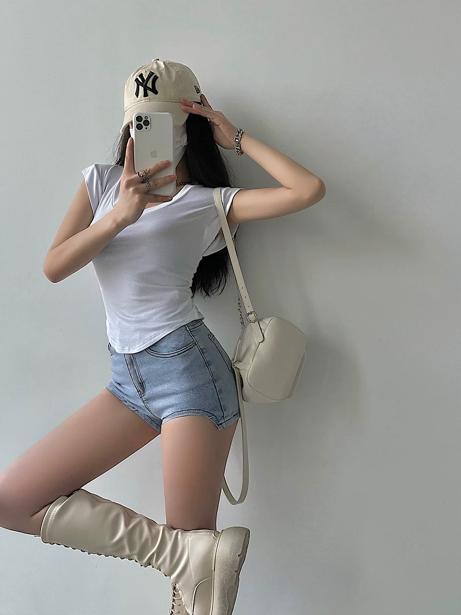 Quần short denim hình vòng cung không đều, cạp cao, gợi cảm của YoungGirlDay, khoe đôi chân dài và che hông.