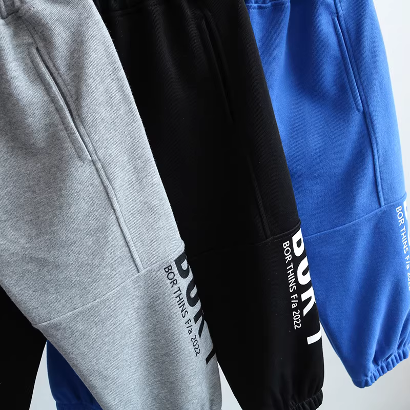 Quần thể thao trẻ em xuân 2025 kiểu mới, quần lửng in chữ rộng rãi, quần dài thời trang cho bé trai, quần jogger ống rộng hợp xu hướng