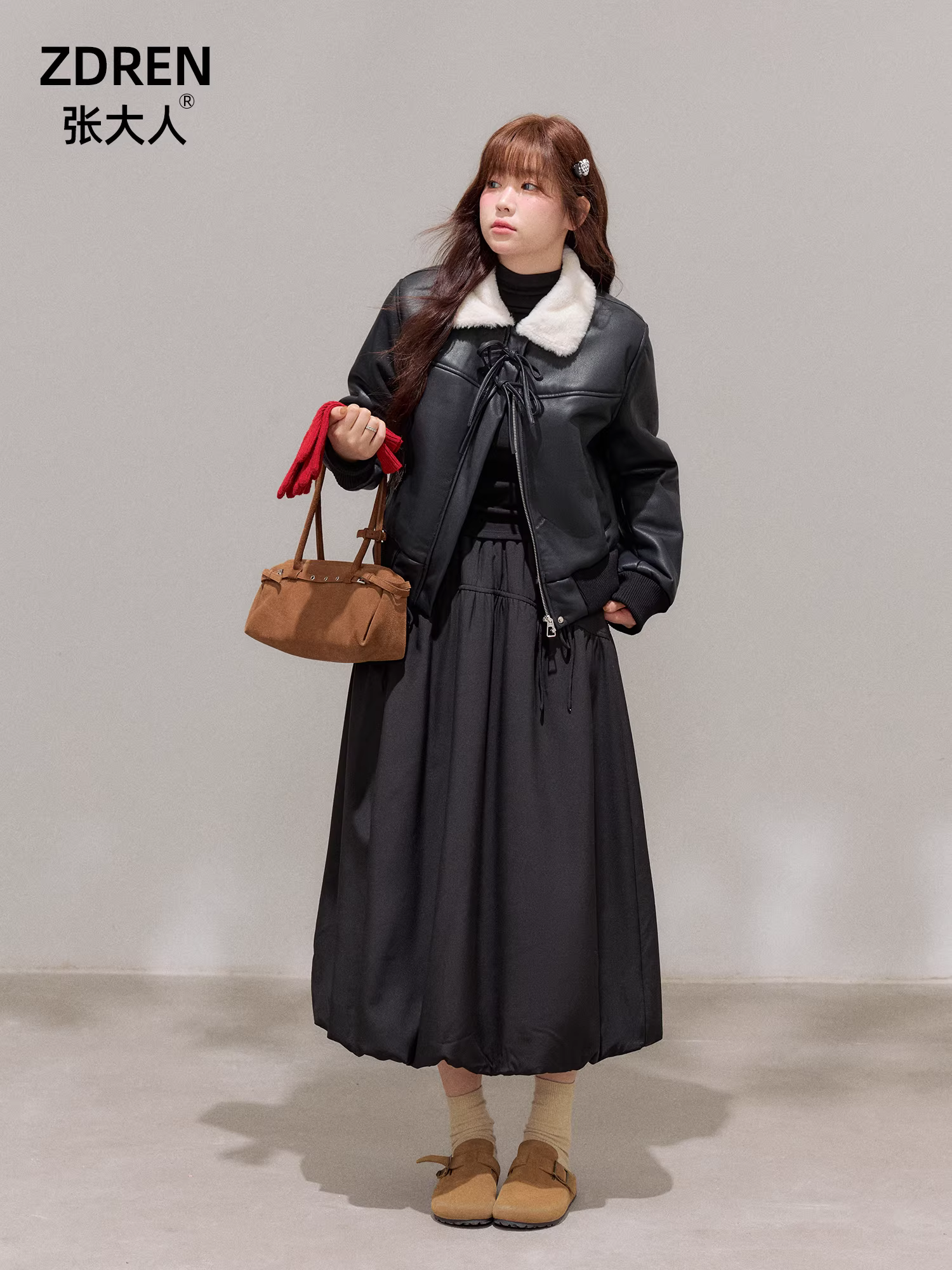 Bộ trang phục mùa đông cho nữ cỡ lớn: Áo khoác da đen tôn dáng với cổ lông trắng và bộ chân váy hoa lưng cao.