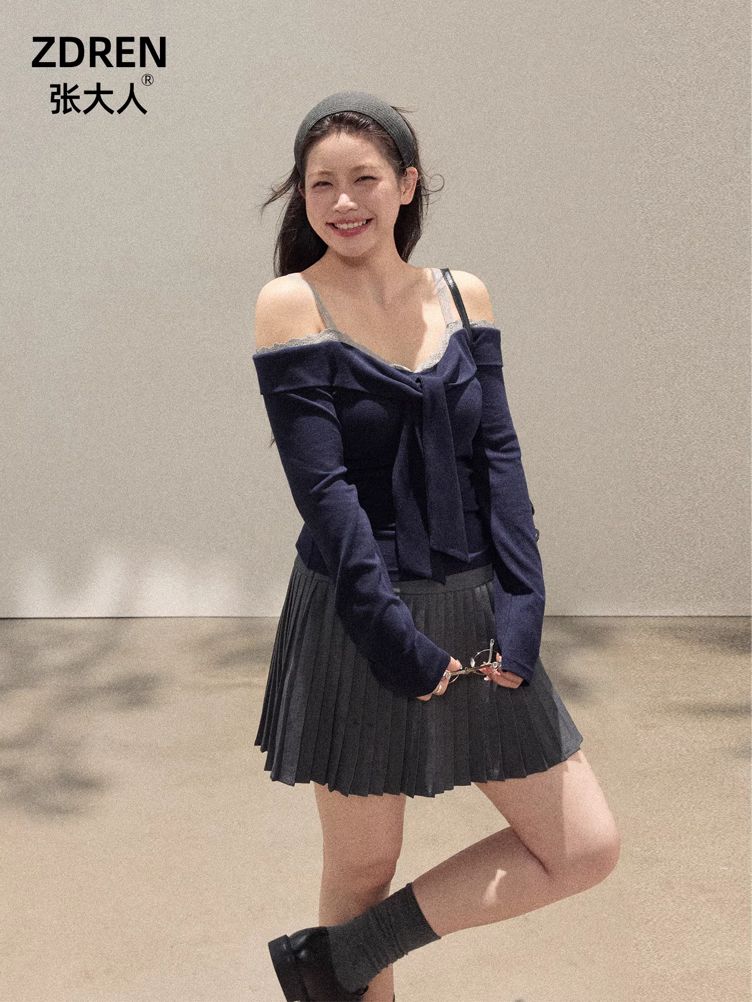 Bộ trang phục nữ cỡ lớn dành cho người lớn, gồm áo trễ vai phối ren và chân váy xếp ly màu xám giúp thon gọn dáng người.