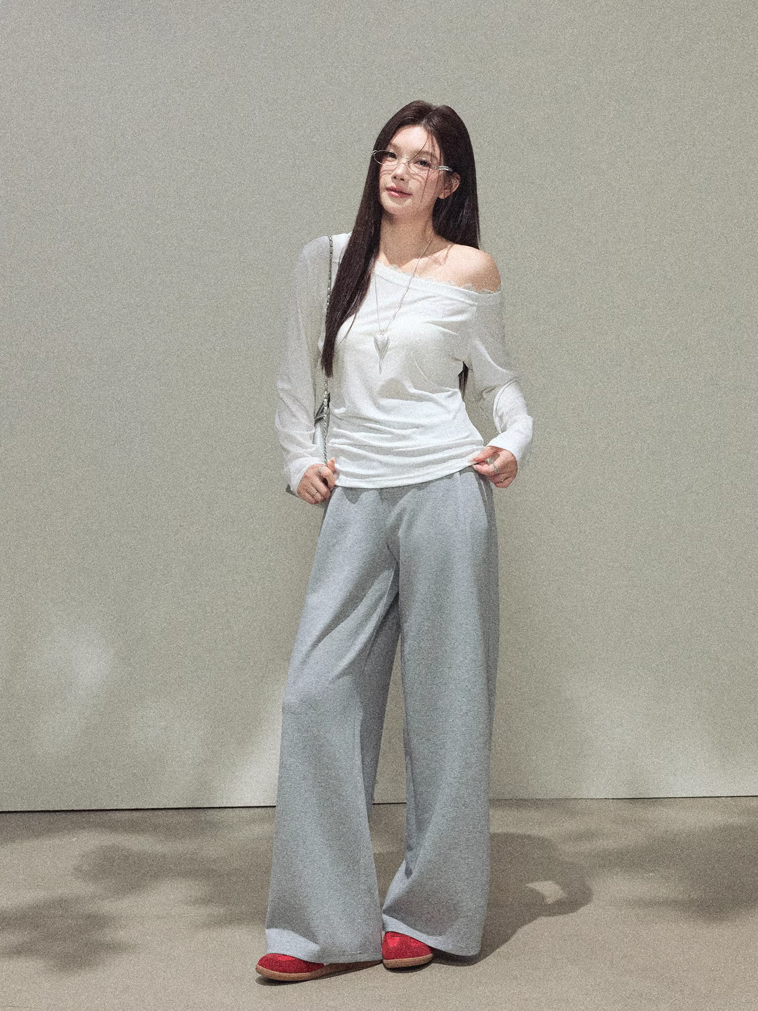 Bộ quần áo nữ cỡ lớn dành cho các cô gái hơi mũm mĩm, gồm áo trắng lệch vai thanh lịch và quần âu lưng cao tôn dáng.