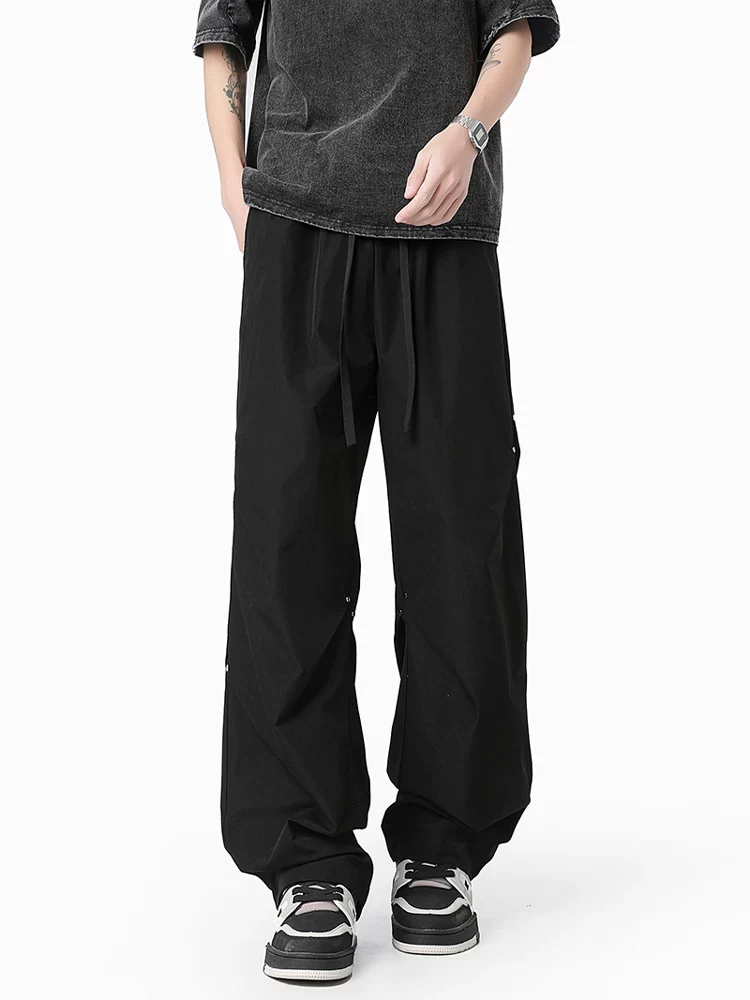 Quần dù xếp ly đính đinh tán Jeanswest dành cho nam, quần ống rộng dáng suông phong cách Mỹ mùa xuân.