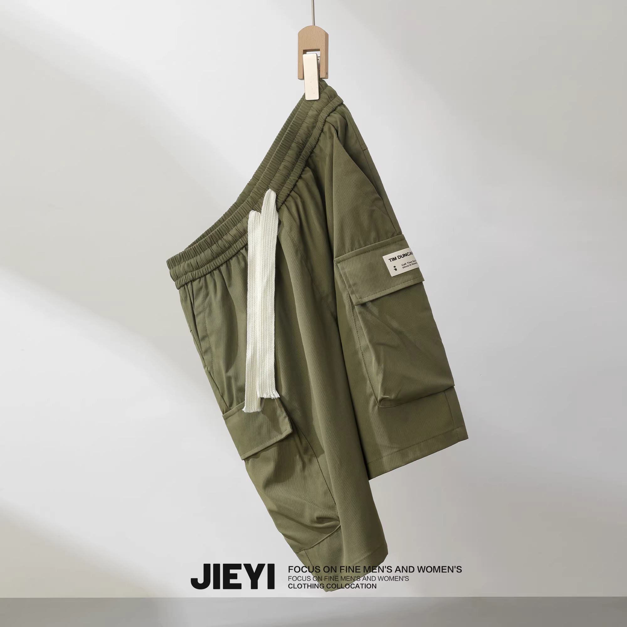 Quần short nam phong cách thường ngày có nhiều túi và nhãn hiệu, quần short dài vừa phải màu trơn, quần short năm điểm, quần nhiều túi thời trang.