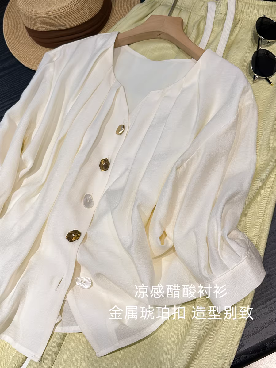 Áo sơ mi nữ tay ba phần, cổ chữ V kiểu Pháp, chất liệu acetate mát mẻ, khóa kim loại màu hổ phách không đều, dáng rộng, tôn dáng, mới cho mùa hè.