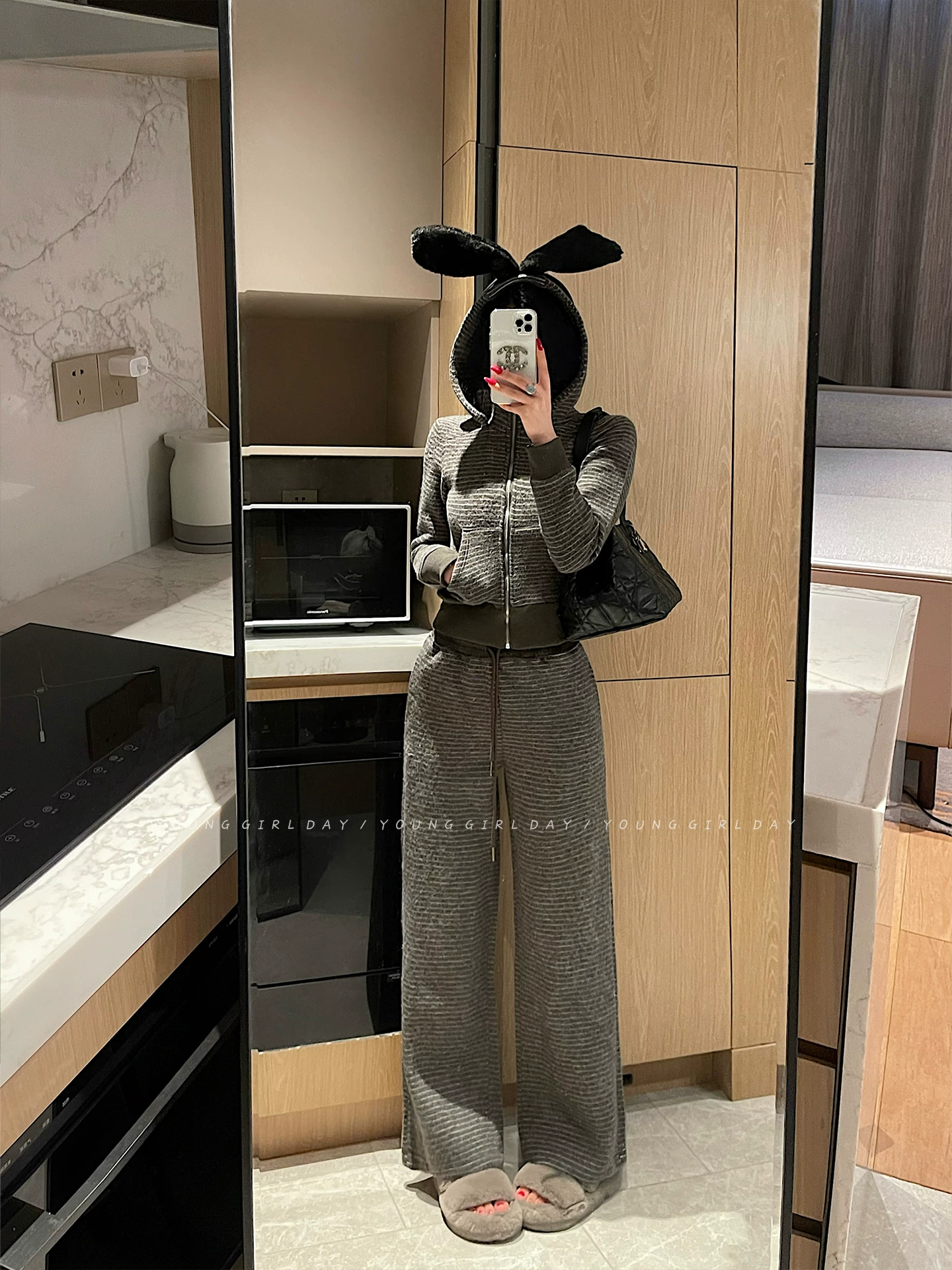 Bộ đồ nữ phong cách YoungGirlDay gồm áo khoác cardigan dày dặn kẻ sọc có khóa kéo và quần dài cạp cao, kiểu dáng thường ngày.