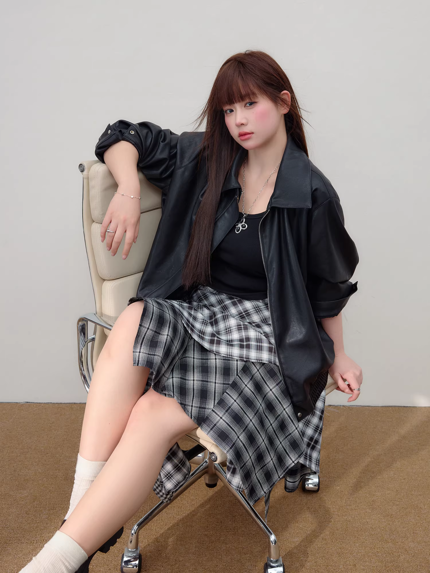 Quần áo nữ cỡ lớn dành cho người lớn, bộ áo khoác da phong cách Hàn Quốc ngọt ngào và cá tính cùng chân váy kẻ caro bất đối xứng.