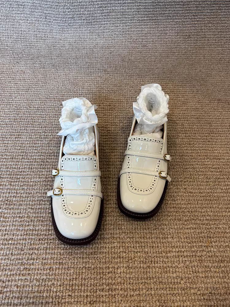 Giày lười da cừu kiểu Anh, chất liệu da bóng, mũi tròn, gót dày, có khóa thắt lưng.