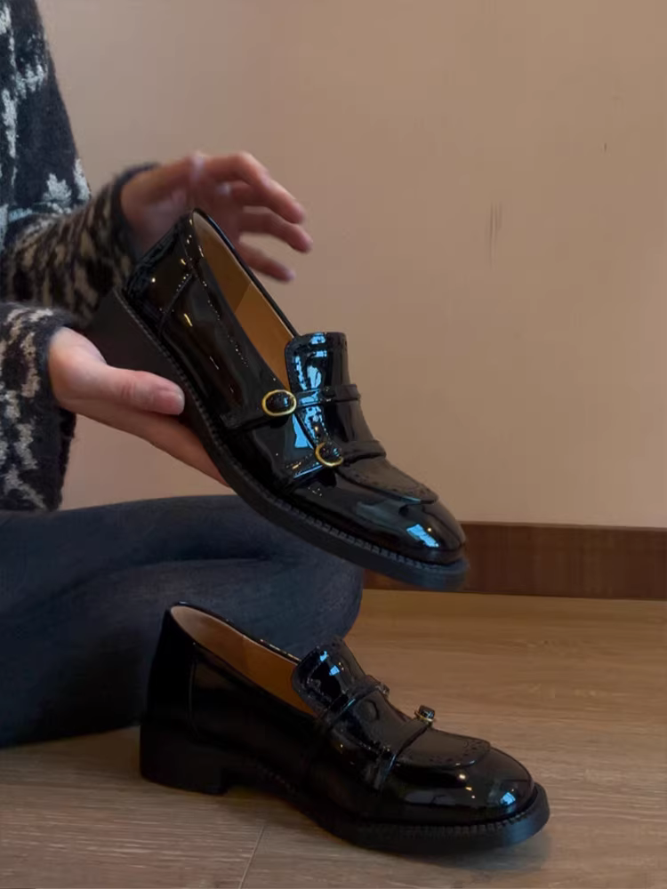 Giày lười da cừu kiểu Anh, chất liệu da bóng, mũi tròn, gót dày, có khóa thắt lưng.