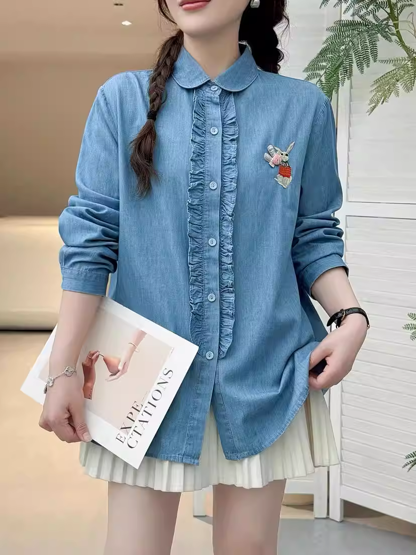 Áo sơ mi denim thêu thỏ mùa thu Dream Box 2025, cổ trụ, tay dài, vạt áo xếp ly, dáng rộng, dành cho nữ.