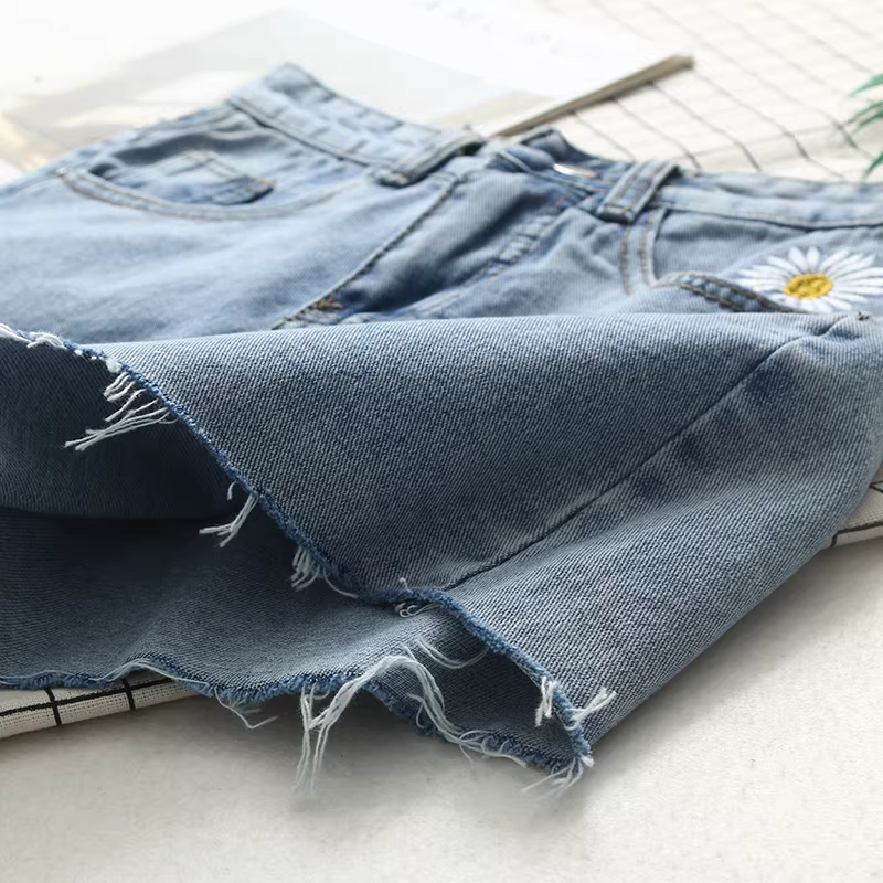 Quần short denim rộng ống, cạp cao, thêu hoa cúc tươi mát, kiểu dáng mới hè 2024, tôn dáng, chất liệu xù nhẹ dành cho nữ