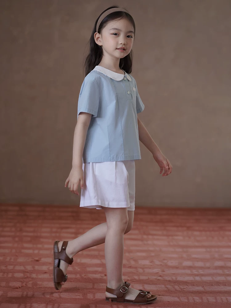 Quần áo trẻ em Hazi Áo trẻ em mùa hè Áo sơ mi ngắn tay phong cách đại học màu xanh Áo sơ mi búp bê dành cho nữ Áo sơ mi cotton thân thiện với da