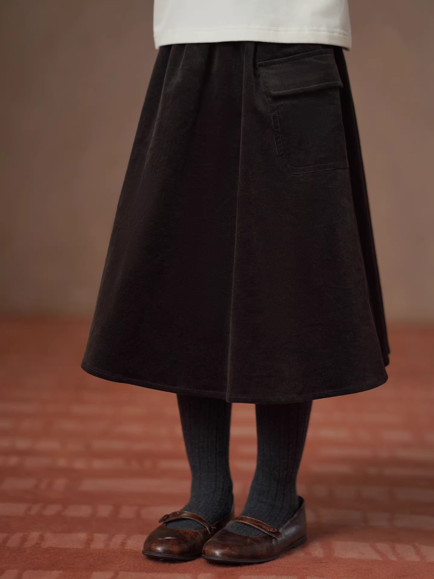 Quần áo trẻ em Hazi 25 Thu Đông Mới Váy nửa thân cho trẻ em Màu cà phê Váy nhung dài vừa phải Váy chữ A cho bé gái