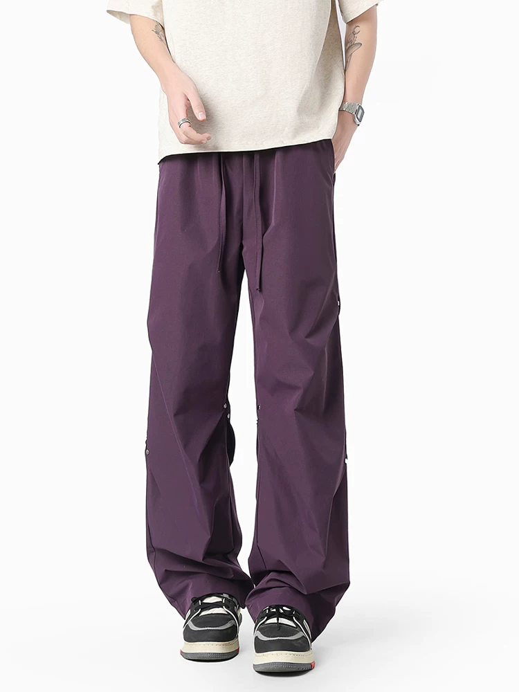 Quần dù xếp ly đính đinh tán Jeanswest dành cho nam, quần ống rộng dáng suông phong cách Mỹ mùa xuân.