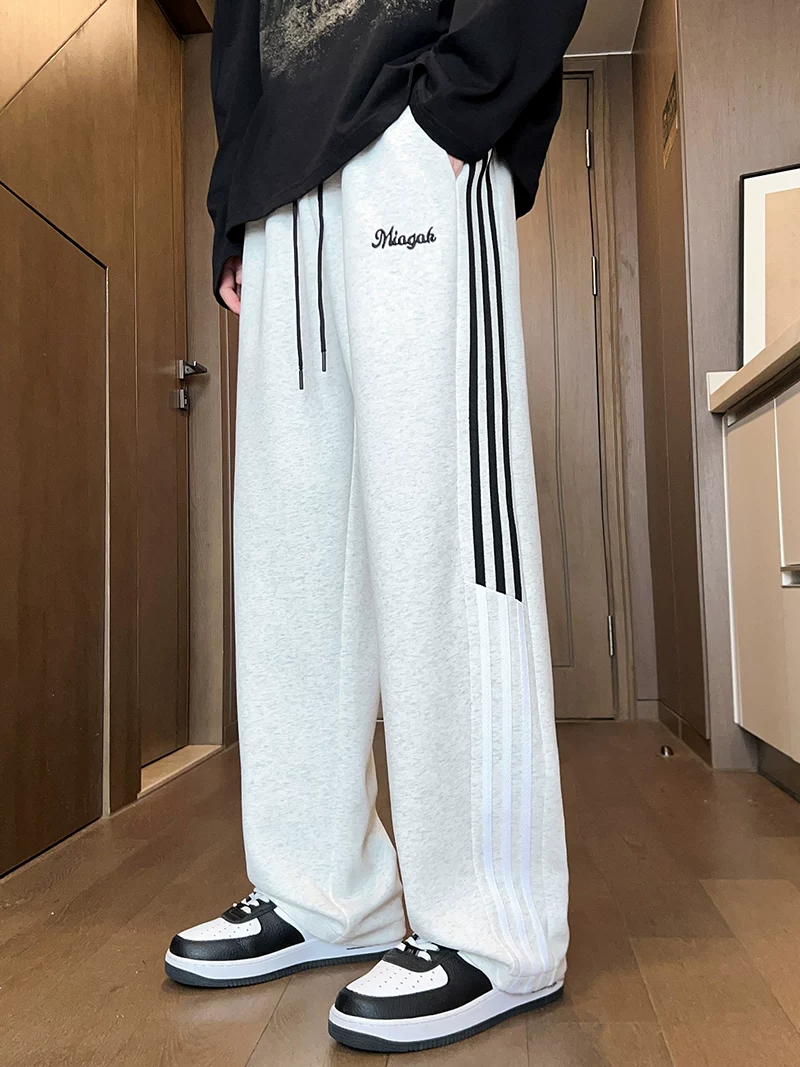 Quần thể thao ống đứng ba sọc phối màu kiểu Mỹ của Jeanswest dành cho nam, mùa xuân thu, quần dài ống rộng dáng rộng mang lại cảm giác cao cấp.