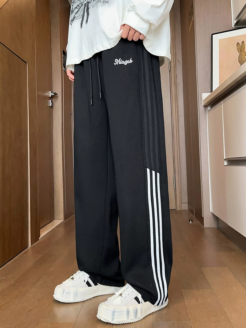 Quần thể thao ống đứng ba sọc phối màu kiểu Mỹ của Jeanswest dành cho nam, mùa xuân thu, quần dài ống rộng dáng rộng mang lại cảm giác cao cấp.