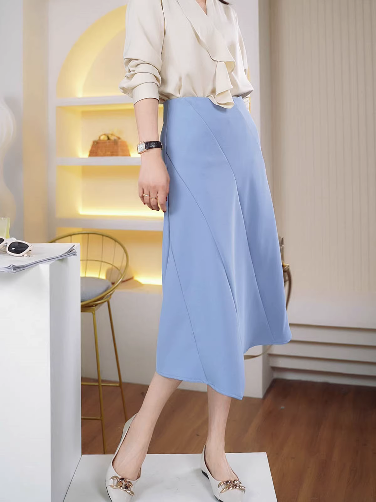 Một chiếc váy midi chữ A cạp cao bất đối xứng màu xanh dành cho đầu mùa xuân.