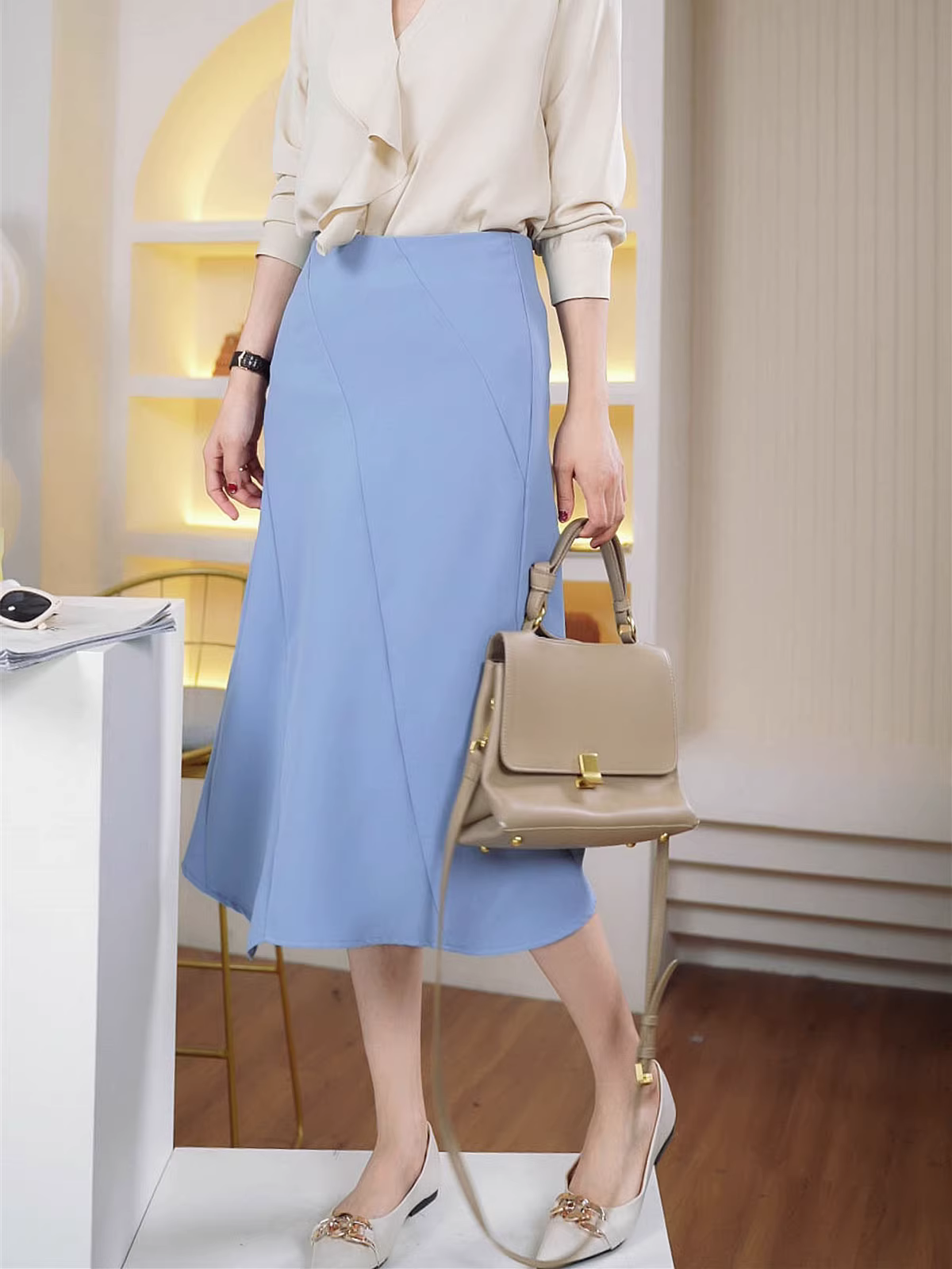 Một chiếc váy midi chữ A cạp cao bất đối xứng màu xanh dành cho đầu mùa xuân.